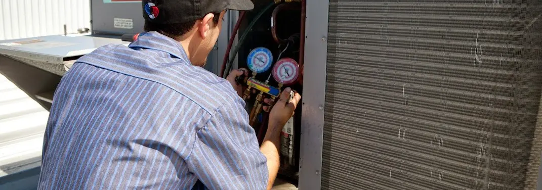 HVAC technician servicing a condenser unit in Brunswick